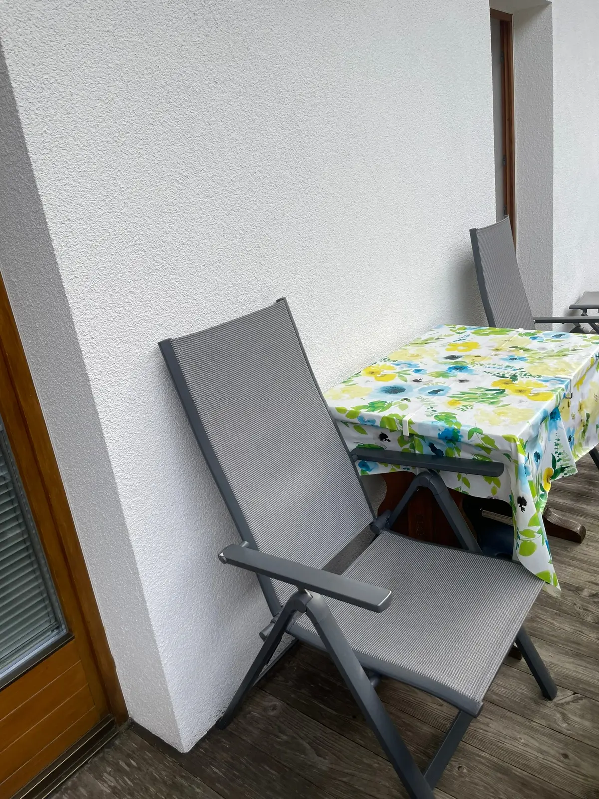 Sitzplatz auf dem Balkon mit Tisch und Gartenstühlen