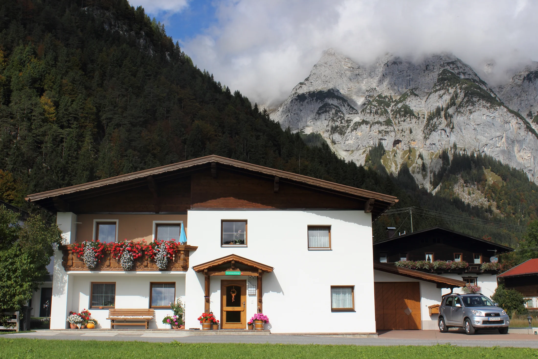 Haus Kuen mit blühendem Balkon vor der Leutascher Bergkulisse