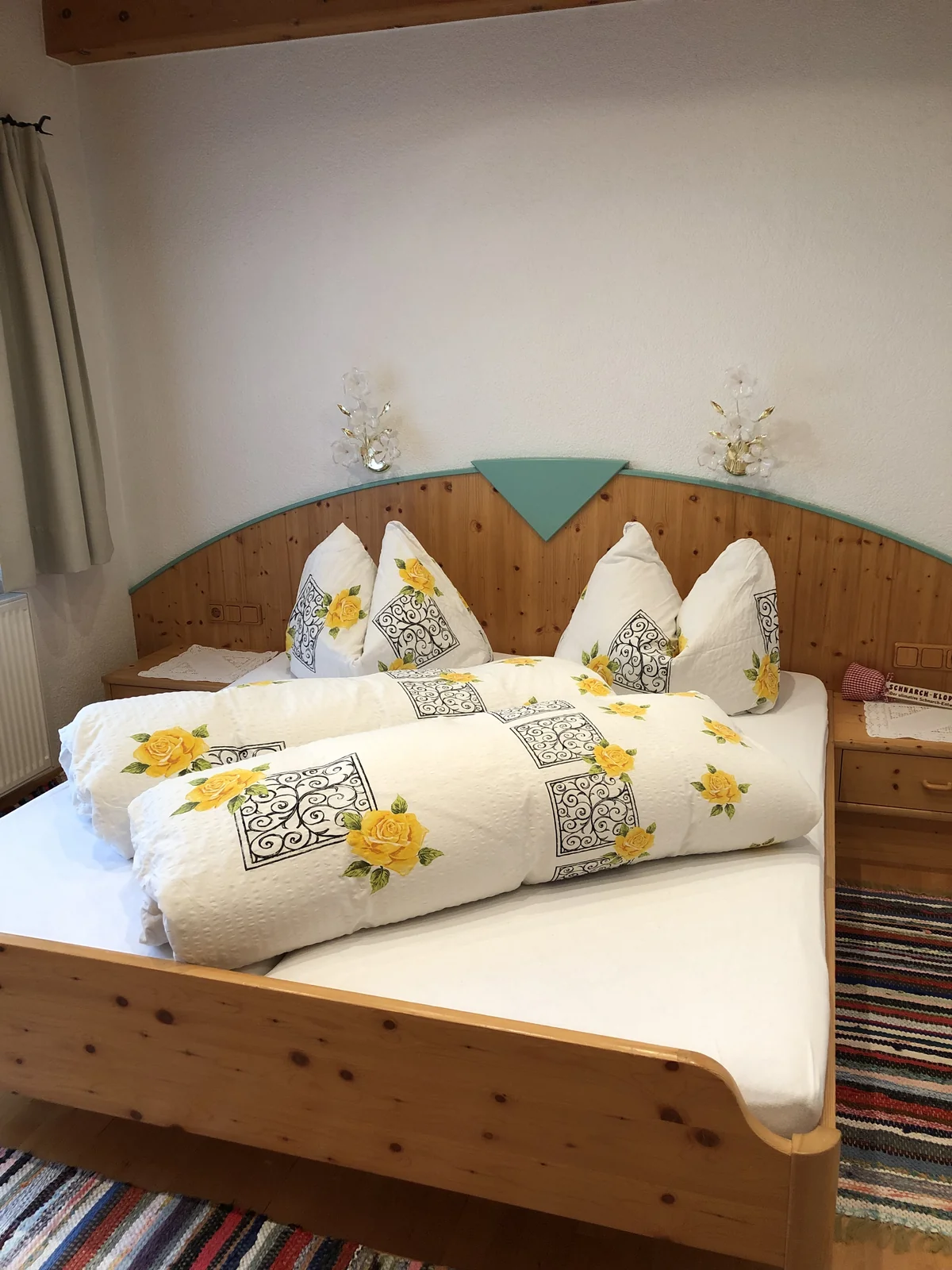 Doppelbett im separaten Schlafzimmer mit heller Blumenbettwäsche