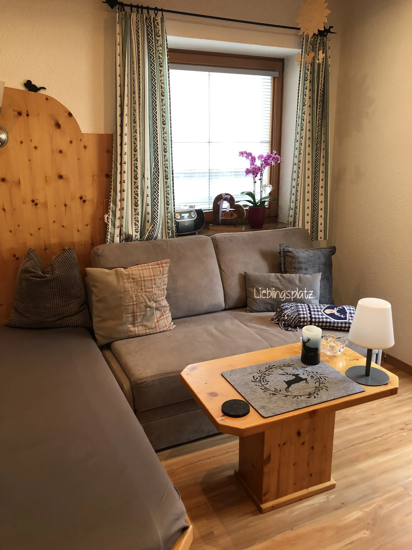 Gemütlicher Wohnbereich mit ausziehbarer Couch, Holztisch und Fenster